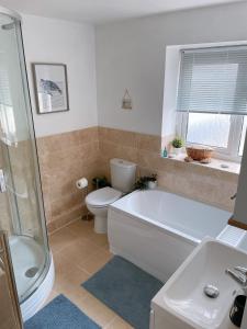 a bathroom with a tub and a toilet and a sink at Plain Sailing 2 min walk to the harbour amazing location in Brixham