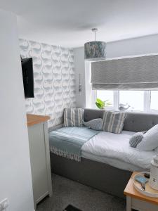 una camera da letto con letto, cuscini e finestra di Plain Sailing 2 min walk to the harbour amazing location a Brixham