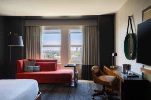 une chambre d'hôtel avec un lit et un canapé rouge dans l'établissement Renaissance Philadelphia Downtown Hotel, à Philadelphie
