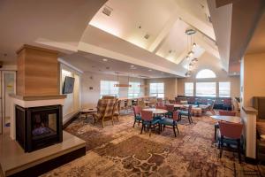 a large room with a fireplace and tables and chairs at Residence Inn by Marriott Pensacola Downtown in Pensacola