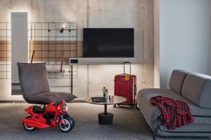 a living room with a couch and a red scooter at Moxy Munich Ostbahnhof in Munich