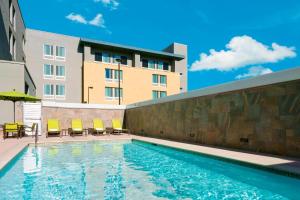 a swimming pool with chairs and a building at SpringHill Suites by Marriott Belmont Redwood Shores in Belmont