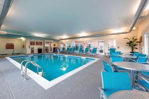 une piscine dans un hôtel avec des chaises et des tables bleues dans l'établissement TownePlace Suites by Marriott Louisville North, à Jeffersonville