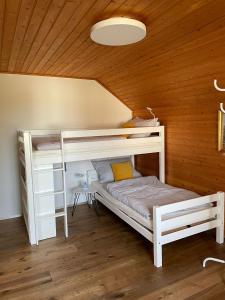 Letto a castello bianco in una camera con soffitto in legno di S´Neunal a Freundorf