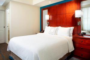 a bedroom with a large bed and a wooden headboard at Residence Inn Columbus Downtown in Columbus
