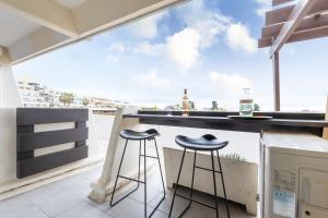 a balcony with two stools at a bar with a view at Zen et Summer Zen coursive naturiste in Cap d'Agde