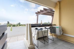 a kitchen with a balcony with a window and stools at Zen et Summer Zen coursive naturiste in Cap d'Agde