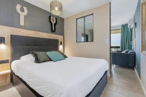 a bedroom with a large bed and a blue couch at Zen et Summer Zen coursive naturiste in Cap d'Agde