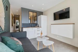 a living room with a couch and a tv at Zen et Summer Zen coursive naturiste in Cap d'Agde