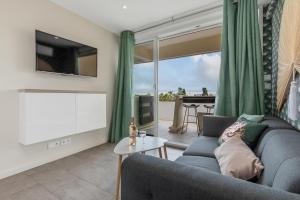 a living room with a couch and a large window at Zen et Summer Zen coursive naturiste in Cap d'Agde
