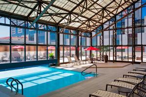 a pool in a building with tables and chairs at San Antonio Marriott Riverwalk in San Antonio