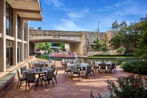 a patio with tables and chairs next to a bridge at San Antonio Marriott Riverwalk in San Antonio
