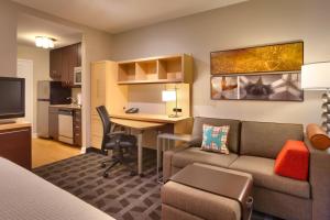 a living room with a couch and a desk in a room at TownePlace Suites Omaha West in Omaha