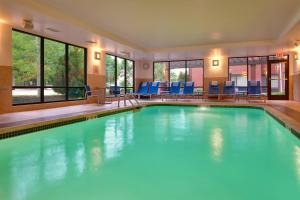 a large swimming pool with blue chairs and windows at TownePlace Suites Omaha West in Omaha