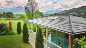 uma casa com um telhado de metal com vista para as montanhas em Ax Hôtel Spa & Restaurant em Chorges