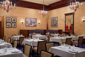 a restaurant with white tables and chairs and chandeliers at Sheraton Ottawa Hotel in Ottawa