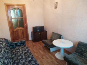 een woonkamer met een bank, een tafel en een tv bij Квартира біля залізничного вокзалу in Vinnytsya
