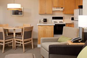 Delta Hotels by Marriott Whistler Village Suites في ويسلار: غرفة معيشة ومطبخ مع أريكة وطاولة