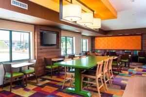 Fairfield Inn & Suites Victoria في فيكتوريا: غرفة طعام مع طاولة خضراء وكراسي