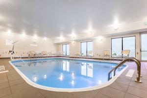 Una piscina en una habitación grande con sillas y mesas. en Fairfield Inn & Suites Victoria, en Victoria