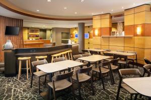 a restaurant with tables and chairs and a bar at SpringHill Suites by Marriott Savannah I-95 South in Savannah