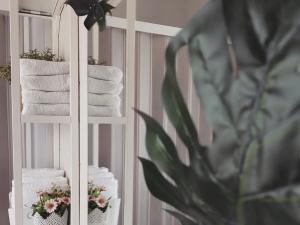 un toallero blanco con toallas y una planta en Dimora Virone Paradiso, en Naro