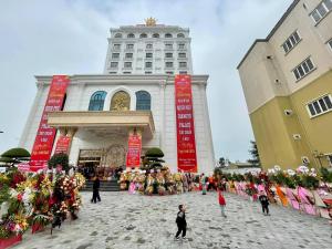 eine Gruppe von Personen, die vor einem Gebäude stehen in der Unterkunft Khách sạn Minh Phú Diamond Palace in Diễn Châu