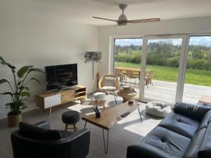 salon z niebieską kanapą i telewizorem w obiekcie Maison de charme vue d'exception w mieście Étreham +36 zdjęć
