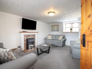 a living room with a couch and a fireplace at Gamekeepers Cottage in Conwy