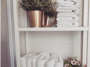 a white shelf with towels and a potted plant at Dimora Virone Paradiso in Naro