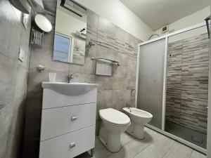 La salle de bains est pourvue de toilettes, d'un lavabo et d'une douche. dans l'établissement Hotel Alla Fontanella, à Alassio