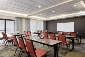 a conference room with tables and chairs and a whiteboard at Courtyard by Marriott Tulsa Central in Tulsa
