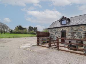 a barn with a wooden fence next to a building at Oak Cottage in Conwy