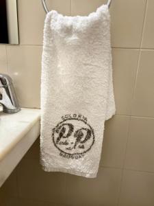 - une serviette suspendue à un lavabo dans la salle de bains dans l'établissement Hotel Perla del Plata, à Colonia del Sacramento
