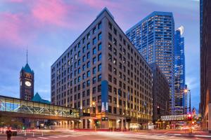 Un palazzo alto con una torre dell'orologio in una città di Emery Hotel, Autograph Collection a Minneapolis