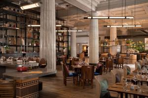 um restaurante com mesas e cadeiras e um bar em Emery Hotel, Autograph Collection em Minneapolis