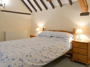 a bedroom with a bed and two night stands at The Old Workshop - Ukc3740 in Bawdeswell