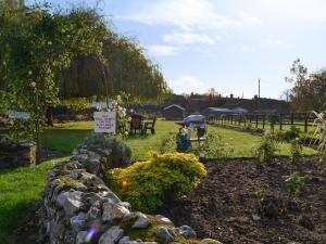 a garden with a stone wall and a sign at The Old Workshop - Ukc3740 in Bawdeswell