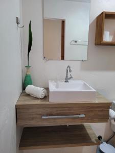 y baño con lavabo blanco y espejo. en Casa Beija-flor en Ilha de Boipeba