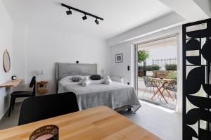 a white bedroom with a bed and a balcony at Athens-Riviera luxury apartment sea view Voula in Athens