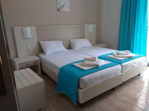 - une chambre avec un lit et des serviettes dans l'établissement Delfini, à Nydri
