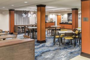a restaurant with tables and chairs and a bar at Fairfield Inn & Suites Kansas City Overland Park in Overland Park
