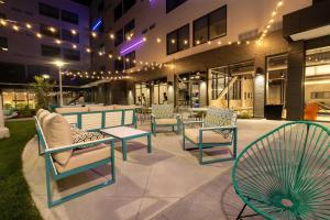 a group of chairs and tables in front of a building at Aloft St. Louis Cortex in Saint Louis