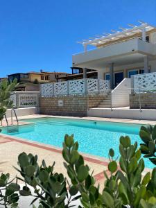 a villa with a swimming pool in front of a house at Aqualife luxury apartment in Arzachena