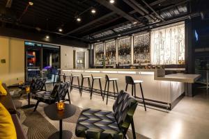 a restaurant with a bar with chairs and a counter at Aloft St. Louis Cortex in Saint Louis