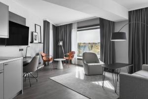 a living room with a couch and a table and chairs at Residence Inn by Marriott Munich Ostbahnhof in Munich