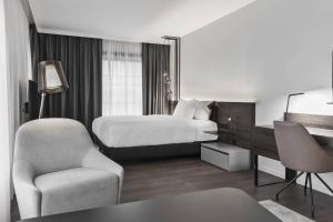 a hotel room with a bed and a chair at Residence Inn by Marriott Munich Ostbahnhof in Munich