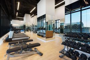 a gym with rows of treadmills and exercise machines at AC Hotel by Marriott Montreal Downtown in Montreal