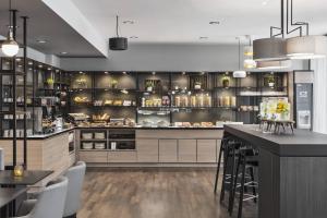a kitchen with a counter and a bar with stools at Residence Inn by Marriott Munich Ostbahnhof in Munich