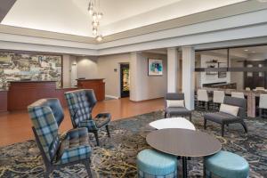 a lobby with chairs and tables and a bar at Residence Inn by Marriott Covington Northshore in Covington